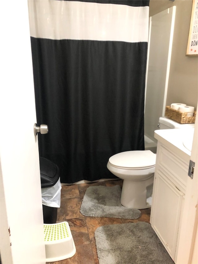 bathroom with toilet, vanity, and tile patterned floors