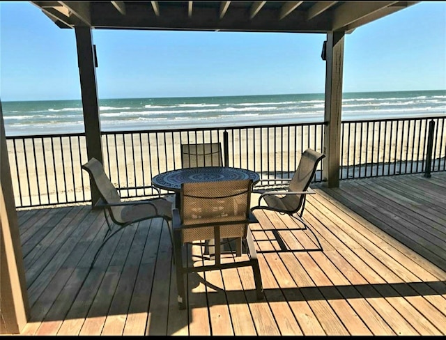 wooden deck featuring a view of the beach and a water view