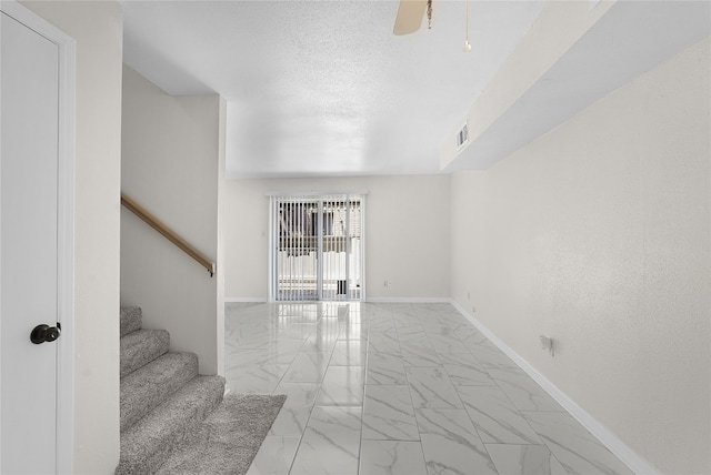 empty room with ceiling fan and light tile patterned floors