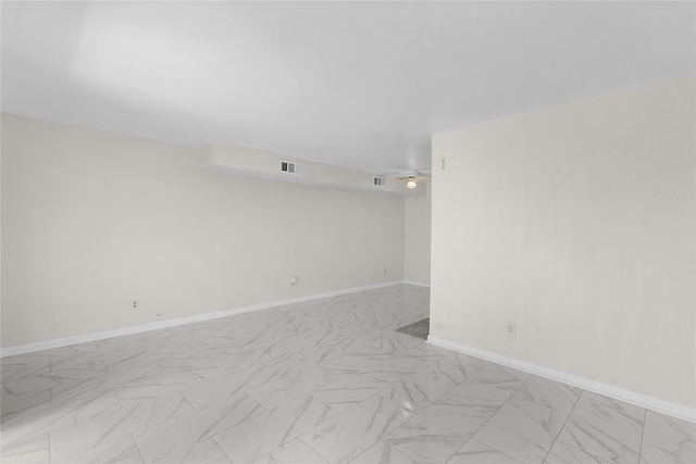 empty room featuring marble finish floor, baseboards, and visible vents