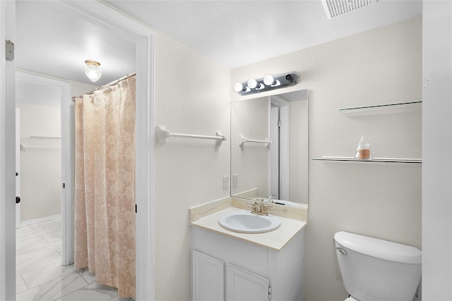 bathroom featuring tile patterned flooring, toilet, and vanity