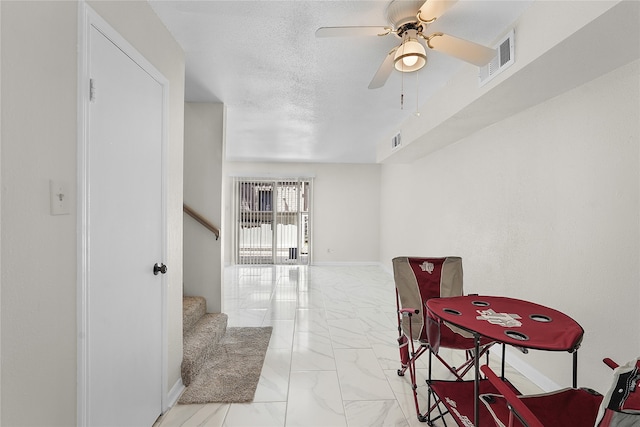 hall with light tile patterned flooring and a textured ceiling