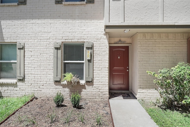 property entrance featuring brick siding