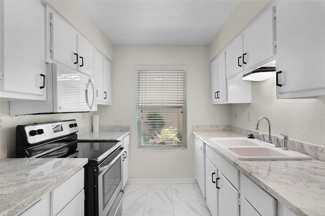 kitchen with sink, light tile patterned floors, light stone counters, white appliances, and white cabinetry