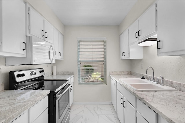 kitchen with white appliances, a sink, baseboards, white cabinets, and marble finish floor