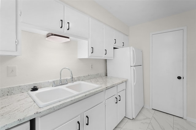 kitchen featuring white cabinetry, sink, light tile patterned flooring, and white fridge