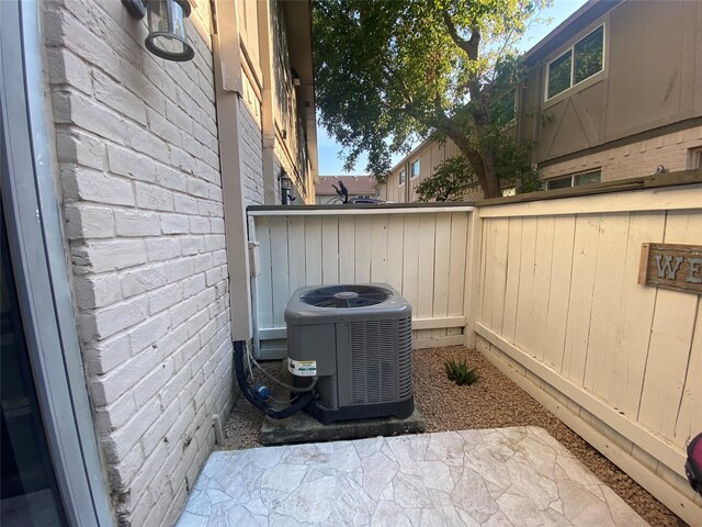 details with brick siding, fence, and central air condition unit