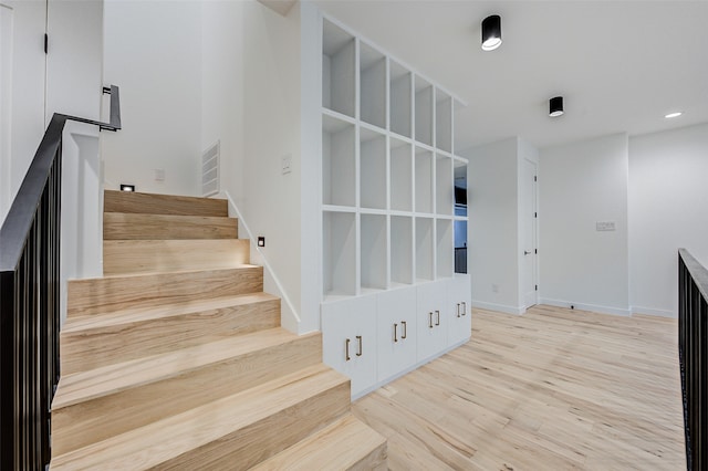 staircase with hardwood / wood-style floors