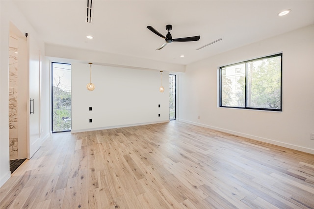 unfurnished room with light wood-type flooring and ceiling fan