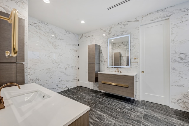 bathroom featuring vanity and tile walls