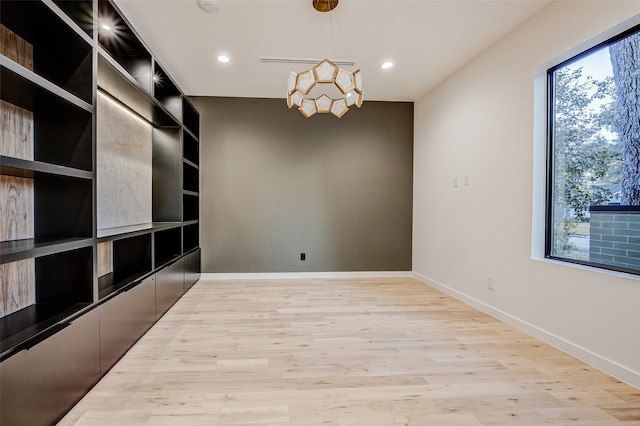 spare room featuring light wood-type flooring and plenty of natural light