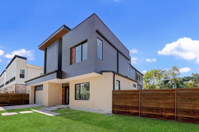 rear view of property with a yard and a garage