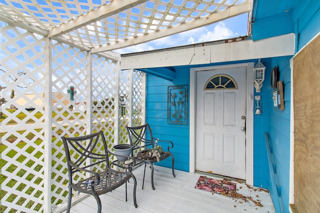 entrance to property with a pergola and a deck