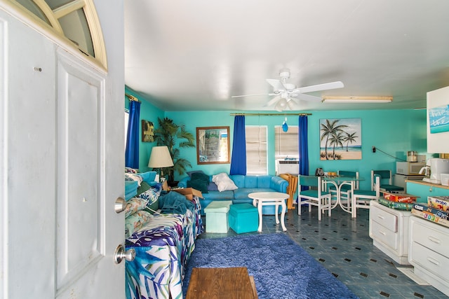 living room featuring ceiling fan and dark tile patterned floors