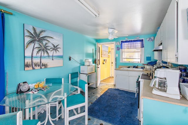 kitchen with ceiling fan, white cabinetry, light tile patterned flooring, and extractor fan