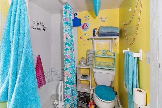 bathroom featuring shower / bathtub combination with curtain and toilet