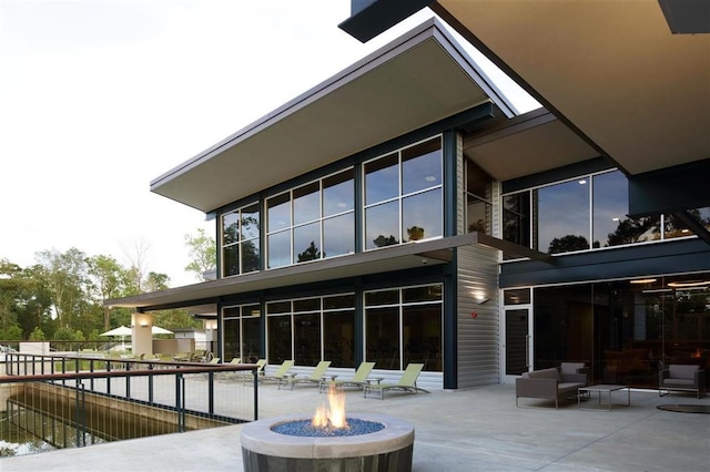 rear view of property featuring an outdoor fire pit and a patio area