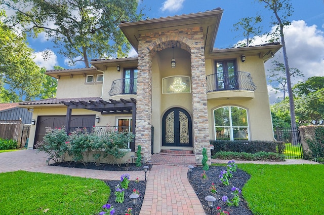 mediterranean / spanish house with decorative driveway, french doors, stucco siding, fence, and a balcony