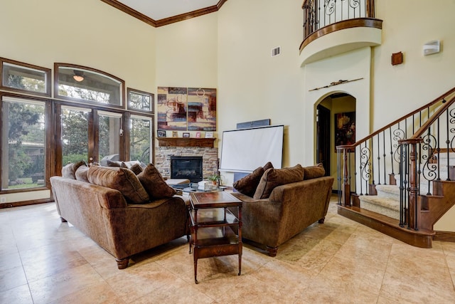 tiled living room with a fireplace, ornamental molding, and a high ceiling