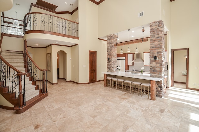 interior space with a towering ceiling, decorative columns, and sink