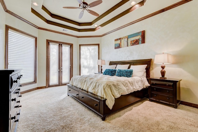 bedroom featuring a raised ceiling, crown molding, and light carpet