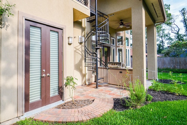 view of exterior entry with ceiling fan, fence, french doors, stucco siding, and a patio area