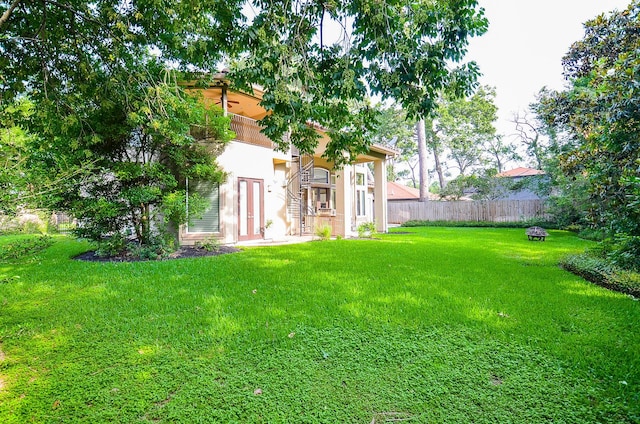 view of yard featuring an outdoor fire pit and fence