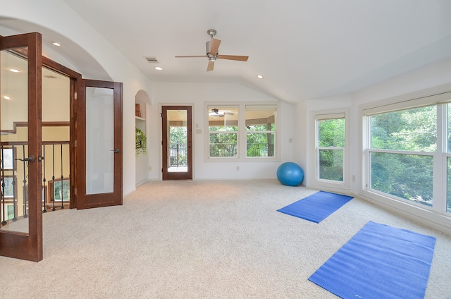 workout room featuring ceiling fan, vaulted ceiling, carpet floors, and french doors