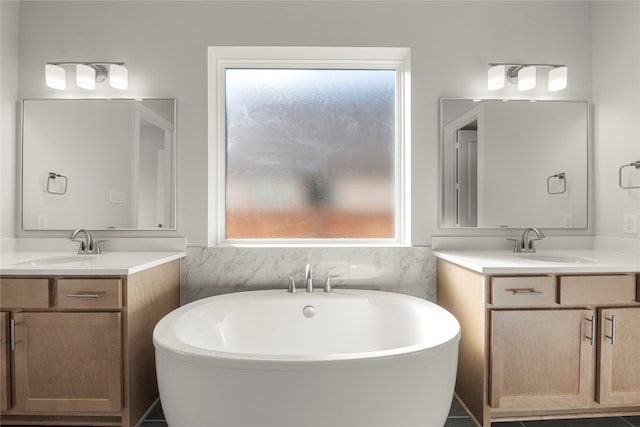 bathroom featuring a healthy amount of sunlight, vanity, and a bathing tub