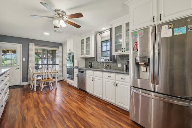 kitchen featuring dark hardwood / wood-style flooring, backsplash, appliances with stainless steel finishes, white cabinetry, and ceiling fan