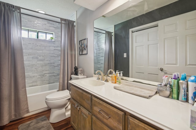 full bathroom featuring toilet, hardwood / wood-style floors, vanity, a textured ceiling, and shower / bath combination with curtain