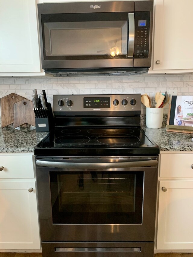 kitchen featuring stainless steel appliances, decorative backsplash, and white cabinets