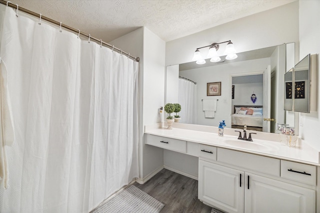 bathroom with vanity, hardwood / wood-style flooring, and a textured ceiling