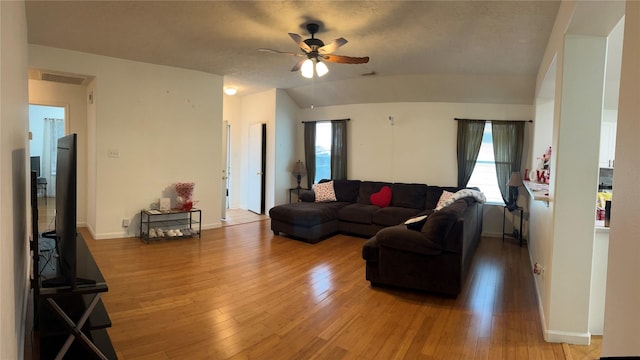 living room with lofted ceiling, ceiling fan, and light hardwood / wood-style flooring