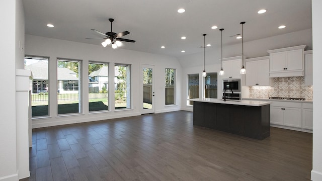17711 Monarch Vista Ln, Conroe, TX 77302 - kitchen featuring stainless steel microwave, open floor plan, cooktop, dark wood-type flooring, and recessed lighting