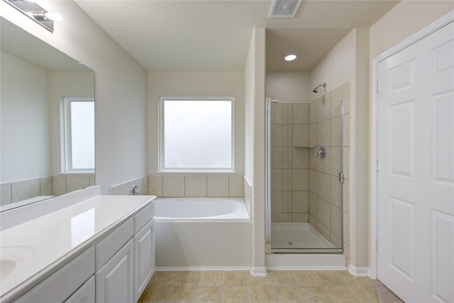 bathroom featuring a textured ceiling, separate shower and tub, vanity, and tile patterned floors