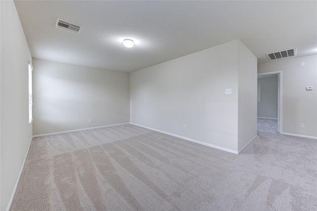 carpeted spare room with a textured ceiling