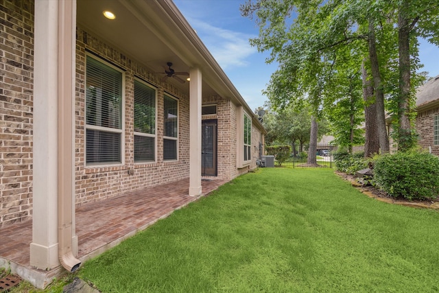 view of yard featuring ceiling fan and central AC unit