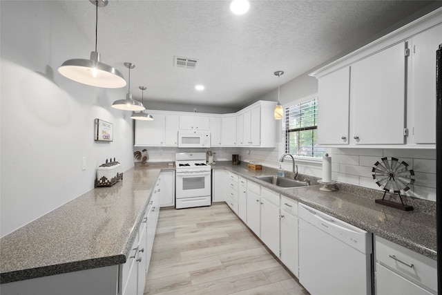 kitchen featuring light hardwood / wood-style floors, backsplash, hanging light fixtures, and white appliances