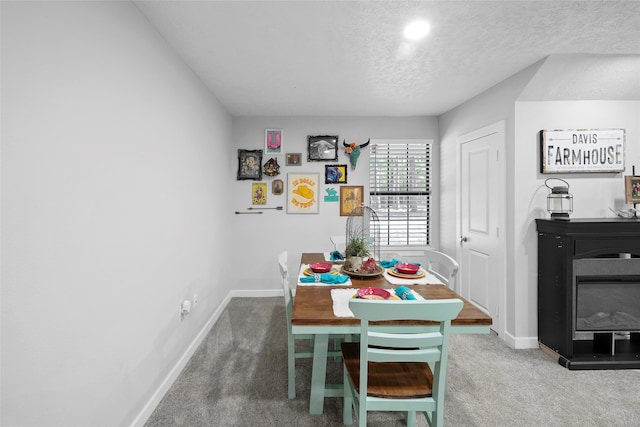 carpeted dining room with a textured ceiling