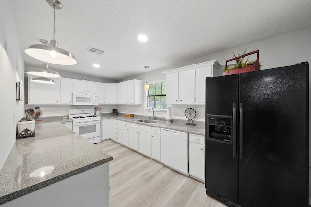 kitchen with white appliances, light hardwood / wood-style floors, decorative backsplash, and decorative light fixtures