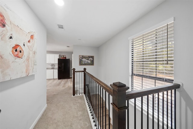 hallway with light colored carpet