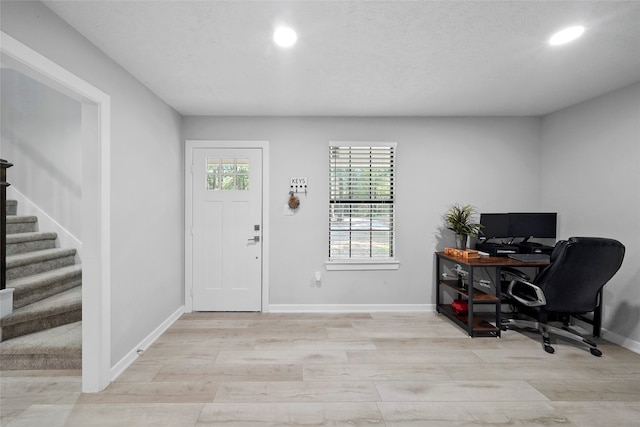 office space with a textured ceiling and light hardwood / wood-style floors