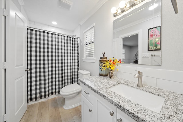 bathroom featuring hardwood / wood-style flooring, crown molding, toilet, and vanity