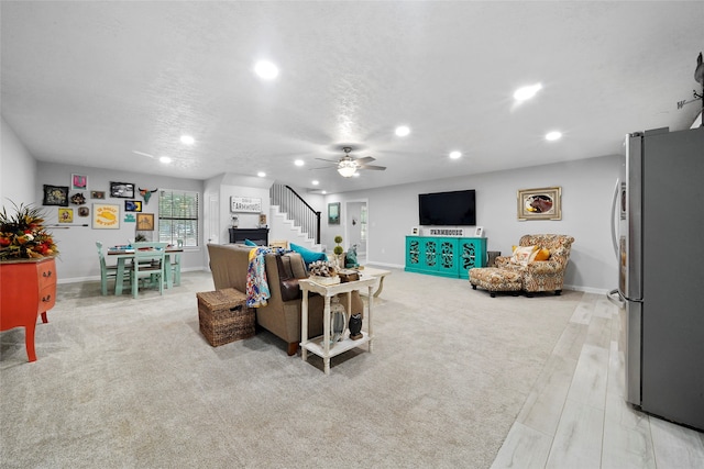 carpeted living room with ceiling fan