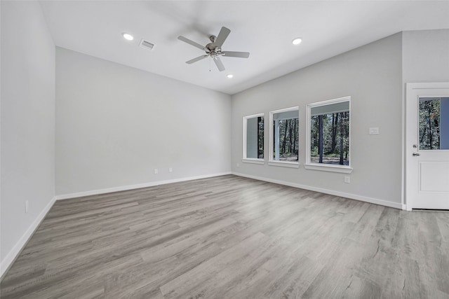 empty room featuring light hardwood / wood-style floors, a wealth of natural light, and ceiling fan