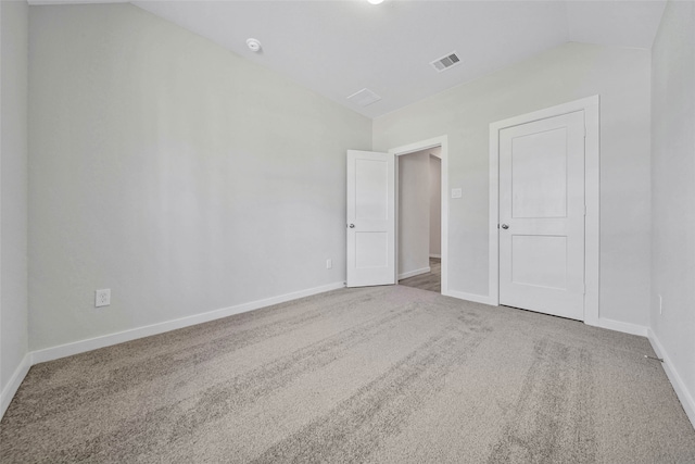 carpeted spare room featuring lofted ceiling