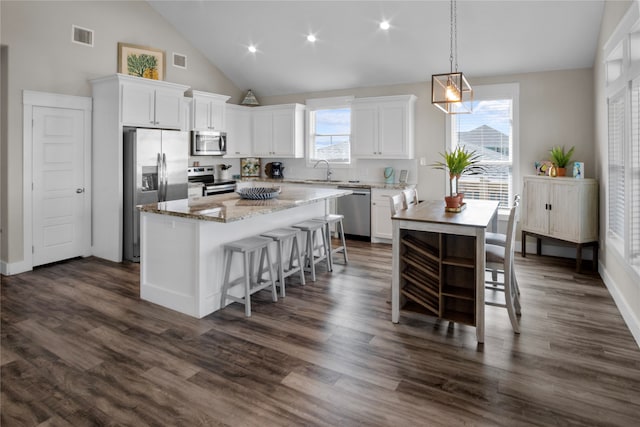 kitchen featuring dark wood-type flooring, high vaulted ceiling, white cabinetry, appliances with stainless steel finishes, and a center island