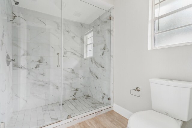 bathroom with an enclosed shower, toilet, and wood-type flooring