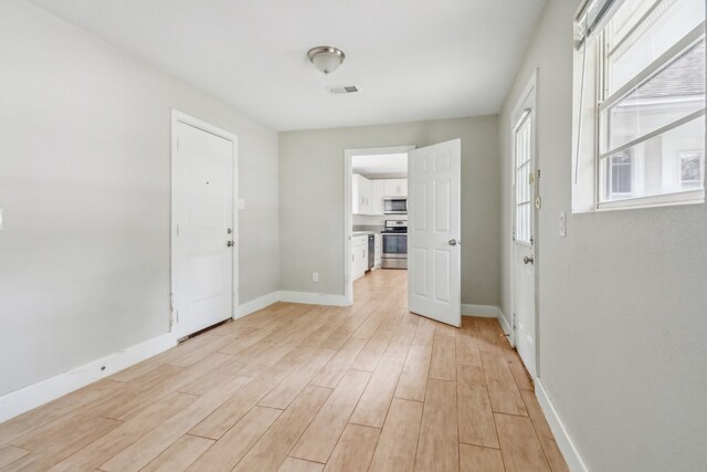 empty room with light hardwood / wood-style flooring